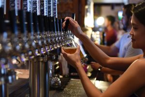 Woman Pouring Beer From Tap